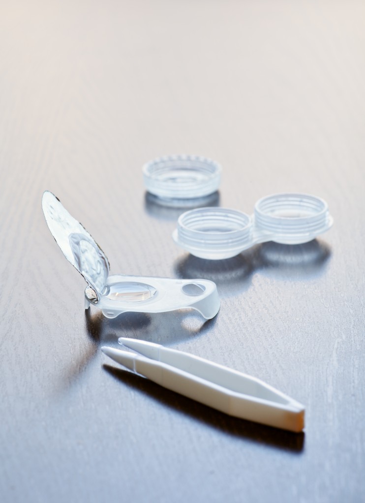Disposable contact lens in open blister-pack with case and tweezers