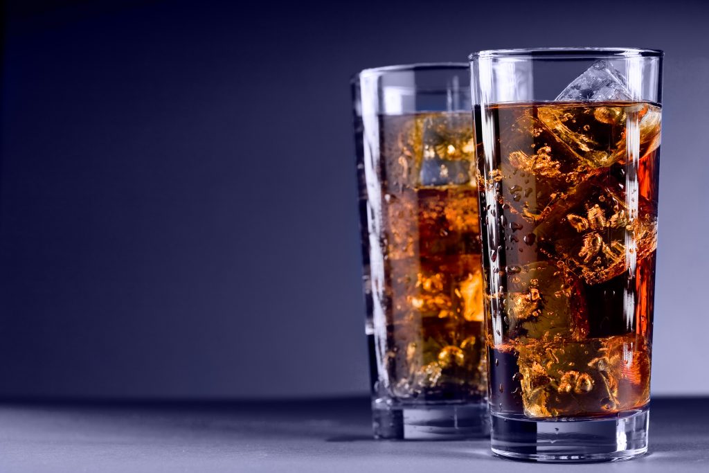 Photo of delicious cold glass with cola and ice cubes