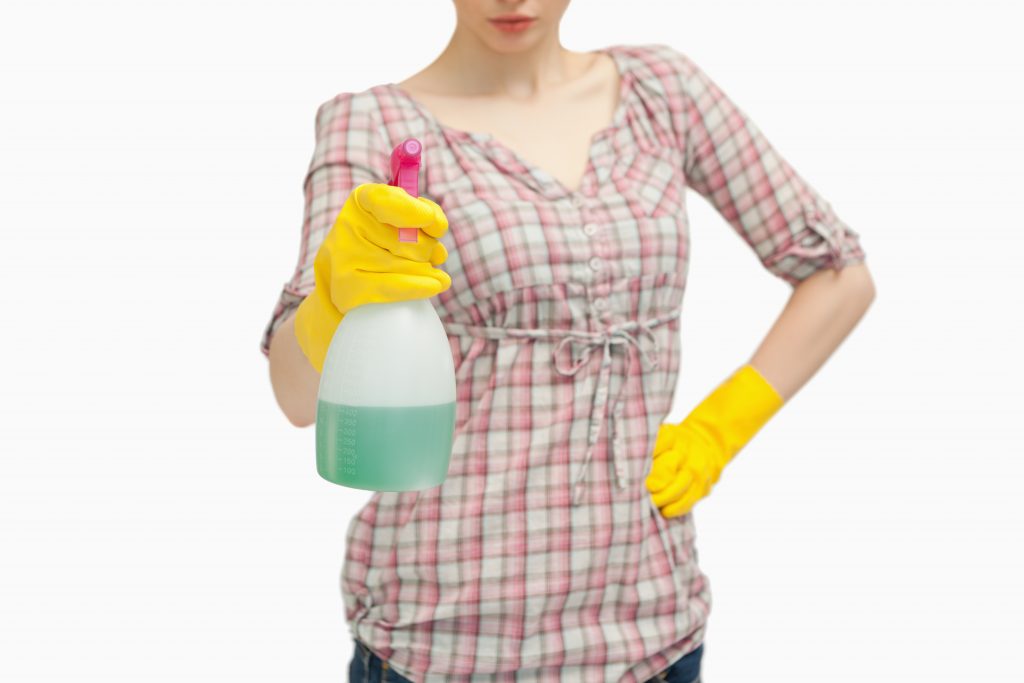 Close up of a woman holding a spray bottle against white background