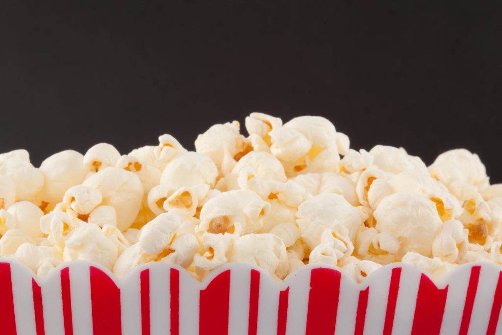Close up of a top of a box full of pop corn against a black background