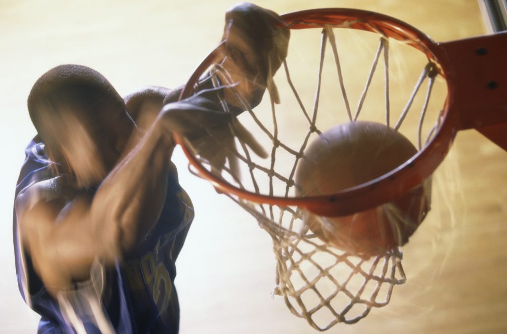 Basketball player slam dunking a ball