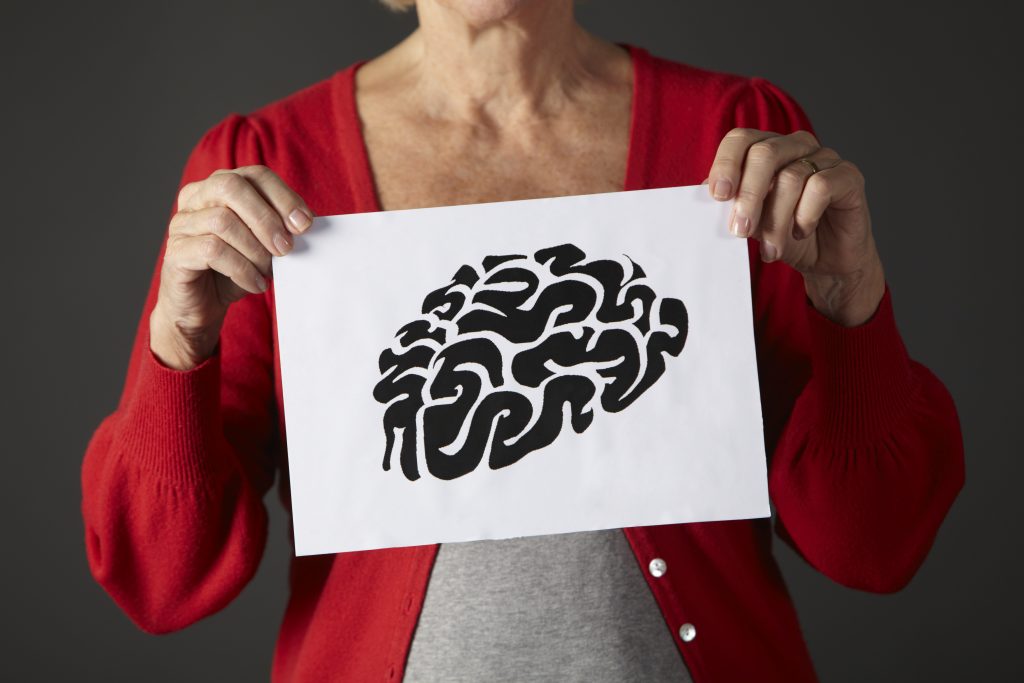 Senior woman holding ink drawing of brain