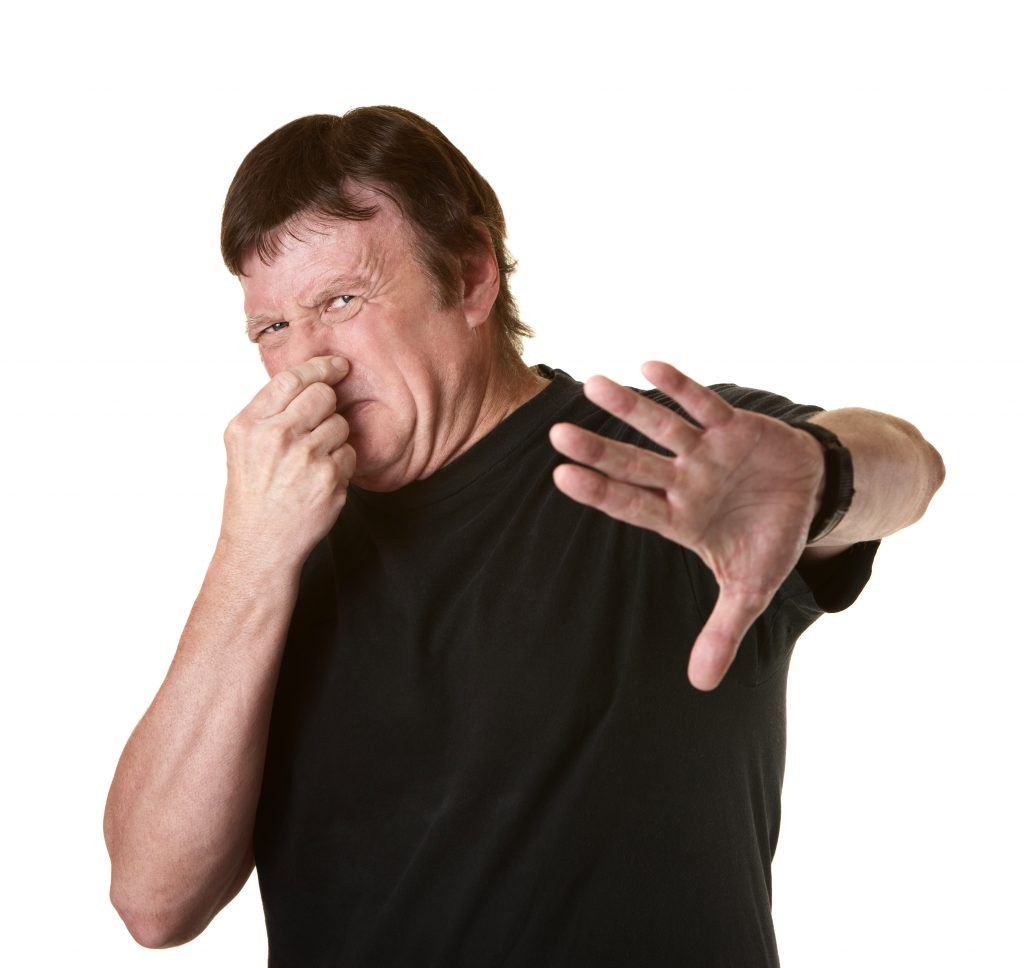 Mature Caucasian man on white background pinches his nose
