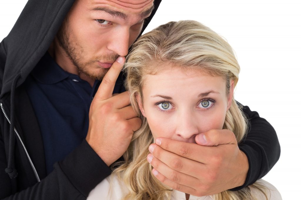 Close up of theft covering young womans mouth over white background