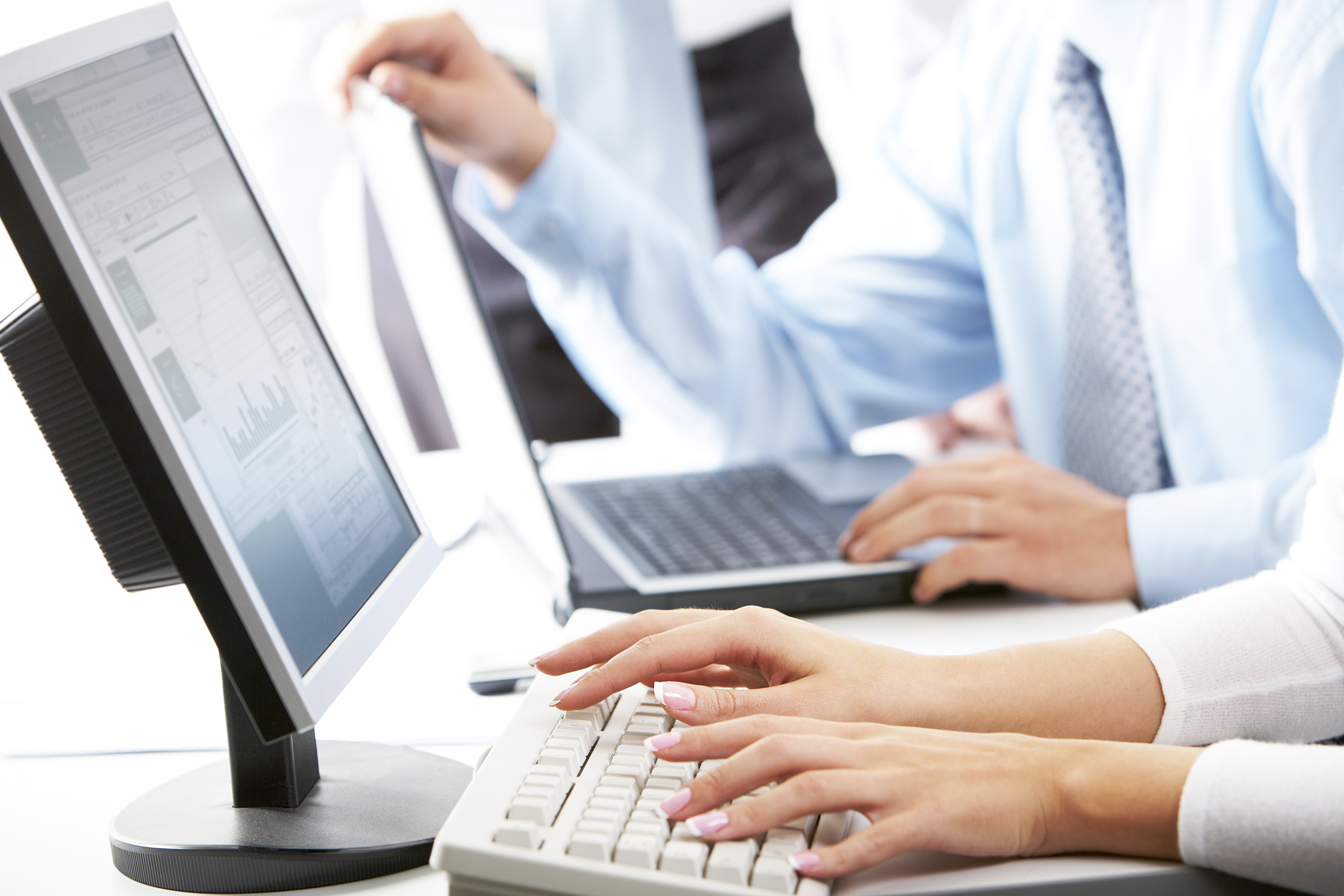 Image of female hands typing on keyboard in working environment